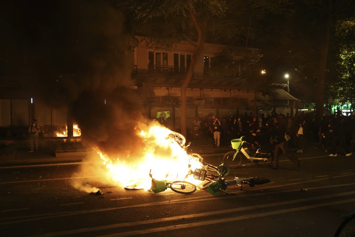 Bicycles burn during tensions near Republique plaza following the second round of the legislative elections, Sunday, July 7, 2024 in Paris. A coalition of the French left that quickly banded together  ...