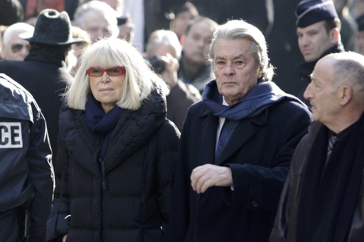 French actor Alain Delon, right, and French actress Mireille Darc arrive at the funeral ceremony of French actress Annie Girardot held at the Saint Roch church in Paris, Friday March 4, 2011. Annie Gi ...