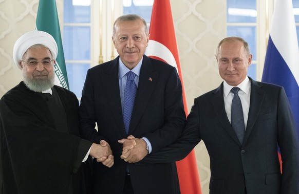 FILE - This Sept. 16, 2019 file photo, from left: Iranian President Hassan Rouhani, Turkish President Recep Tayyip Erdogan and Russian President Vladimir Putin shake hands during their meeting in Anka ...