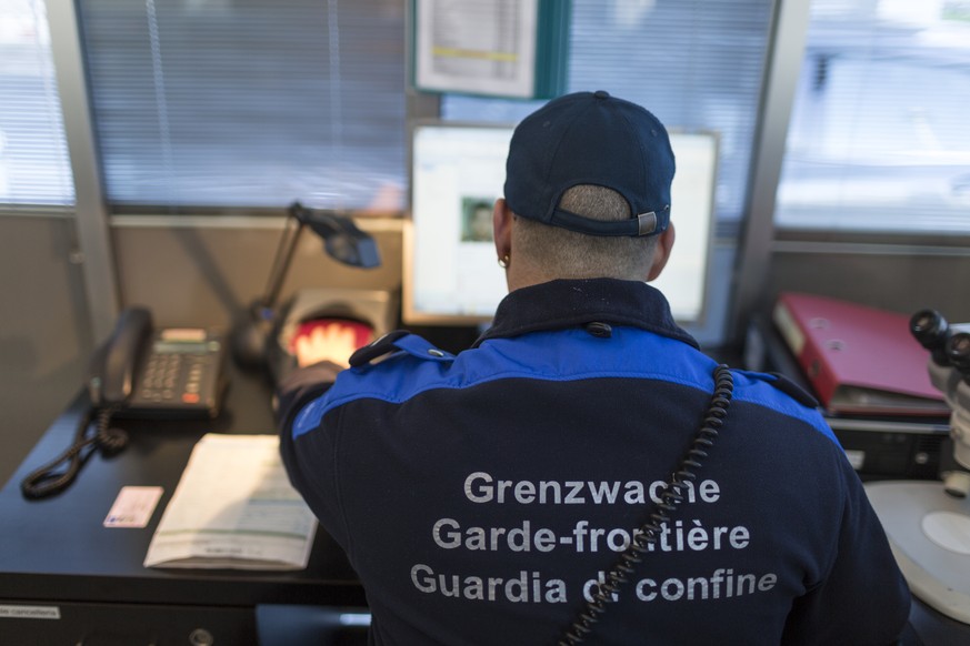 THEMENBILD ZU MASSNAHMEN TERRORBEKAEMPFUNG --- A member of the Swiss Border Guard Corps scanns a passport, captured at the border post in Chiasso, Switzerland, on October 23, 2014. (KEYSTONE/Gaetan Ba ...