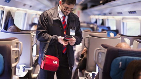 ZUR EINFUEHRUNG DES SWISSPASSES VOR DREI MONATEN STELLEN WIR IHNEN HEUTE, MITTWOCH, 4. NOVEMBER 2015, FOLGENDES NEUES BILDMATERIAL ZUR VERFUEGUNG --- Conductor Salvatore Grade verifies a train passeng ...