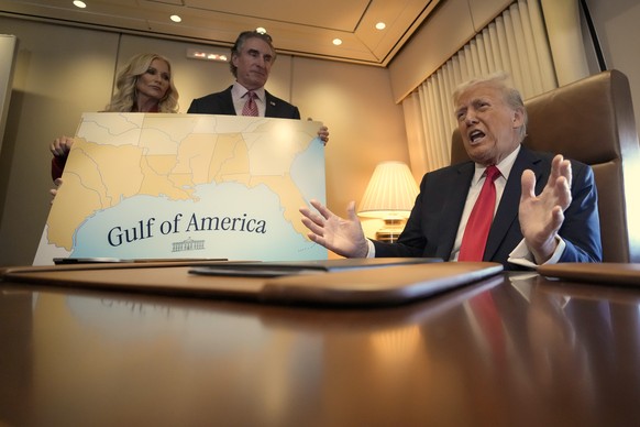 President Donald Trump, from right, speaks to reporters accompanied by Interior Secretary Doug Burgum and Burgum&#039;s wife Kathryn Burgum, aboard Air Force One where Trump signed a proclamation decl ...