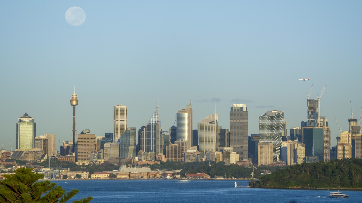 FILE - A plane makes its final approach to Sydney Airport as the full moon sets across the city skyline in Sydney, Australia, on May 17, 2022. Australia faces an unprecedented threat of espionage and  ...