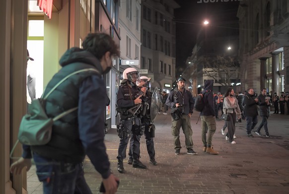 Polizisten beobachten die Situation beim Roten Platz wo sich mehrere hundert Jugendliche besammelt haben, am Freitag, 2. April 2021, in St. Gallen. In der St. Galler Innenstadt haben Jugendliche am Fr ...