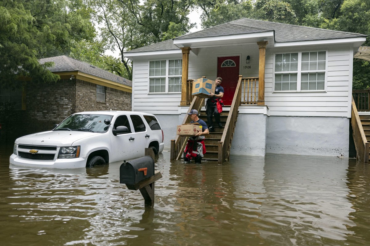 Savannah Fire Advanced Firefighters Ron Strauss, top, and Andrew Stevenson, below, carry food to residents in the Tremont Park neighborhood that where stranded in stormwater from Tropical Storm Debby, ...