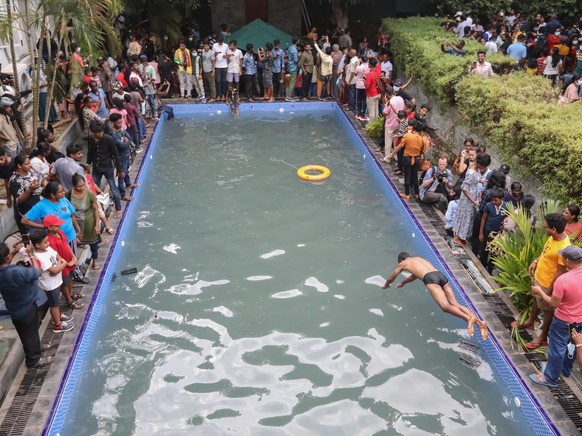 epaselect epa10063875 People take a look at and a dip in a swimming pool at the President&#039;s palace in Colombo, Sri Lanka, 10 July 2022, a day after official residences were stormed. Sri Lankan pr ...