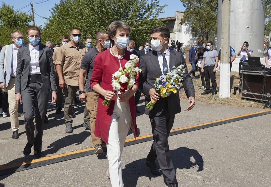 Ukrainian President Volodymyr Zelenskiy, right, and Swiss Federal President Simonetta Sommaruga visit a water pumping station to lay flowers at a memorial for two Ukrainian workers who were killed by ...