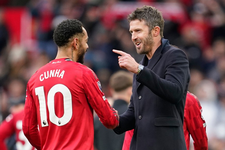 Manchester United's head coach Michael Carrick, right, greets Manchester United's Matheus Cunha after the English Premier League soccer match between Manchester United and Manchester City in ...