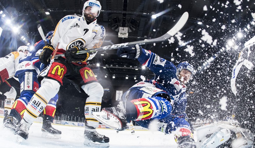 Zuerichs Morris Trachsler, rechts, kaempft gegen Philippe Furrer, links, von Lugano im fuenften Playoff-Viertelfinalspiel der National League A zwischen den ZSC Lions und dem HC Lugano am Dienstag, 14 ...