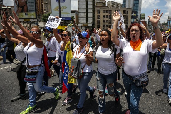 epa05947413 Deputy of the National Assembly, Tamara Adrian (R), participate in an opposition demonstration in Caracas, Venezuela, on 06 May 2017. Thousands of Venezuelan women, opponents of the govern ...