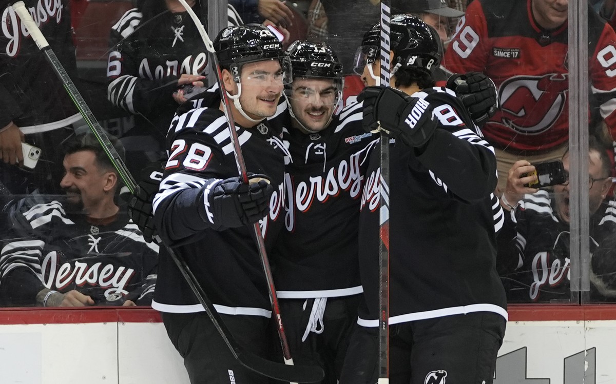 New Jersey Devils' Timo Meier, left, Nico Hischier, center, and Johnathan Kovacevic, right, react after Hischier scored his third goal of the game during the second period of an NHL hockey game a ...