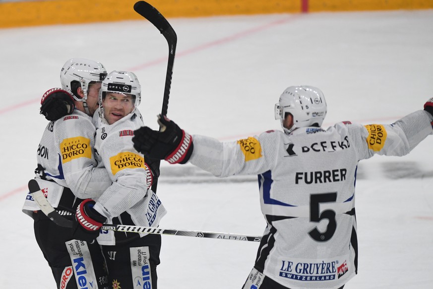 Fribourg&#039;s player Nathan Marchon, Fribourg&#039;s player David Deschernais and Fribourg&#039;s player Philippe Furrer, from left, celebrate the 3-4 goal, during the preliminary round game of Nati ...