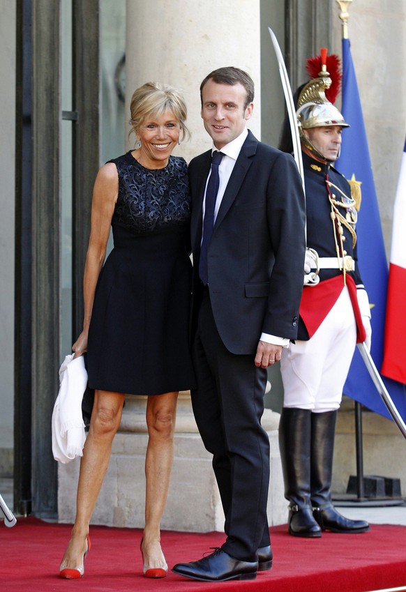FILE - In this June 2, 2015 file photo, then France&#039;s Economy Minister Emmanuel Macron and his wife Brigitte Trogneux pose for photographers as they arrive at the Elysee Palace in Paris. From his ...