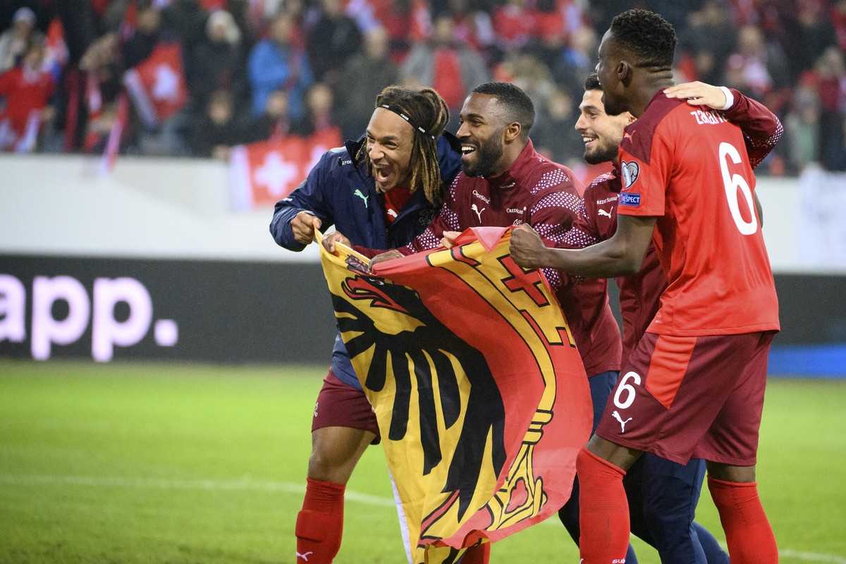 Switzerland's players from Geneva, from left, Kevin Mbabu, Ulisses Garcia, Kastriot Imeri and Denis Zakaria celebrates with the flag of the city of Geneva after directly qualifying for the FIFA W ...
