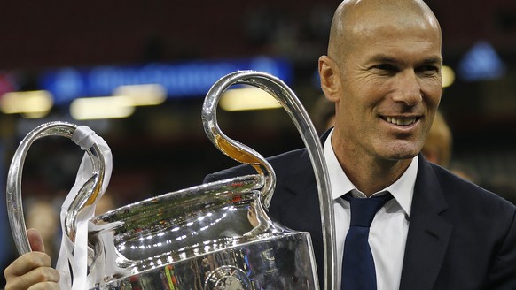 FILE - In this Saturday, June 3, 2017 file photo Real Madrid's head coach Zinedine Zidane celebrates with the trophy at the end of the Champions League soccer final between Juventus and Real Madr ...