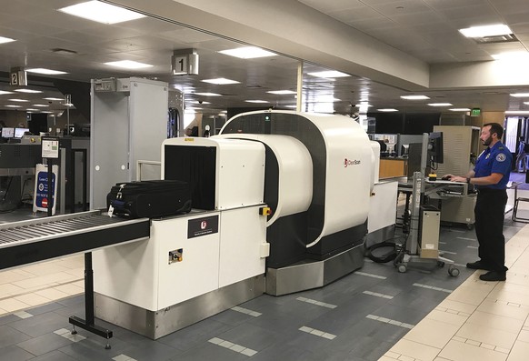 In this Wednesday, June 14, 2017, photo provided by American Airlines, a Transportation Security Administration officer operates an L3 ClearScan baggage screener, featuring 3-D scanning technology, at ...