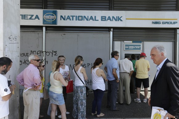 People line up to use ATM machines of a bank after government&#039;s decision for limited daily cash withdrawals to 60 euros ($67), in Athens, on Monday, July 6, 2015. Greek Finance Minister Yanis Var ...