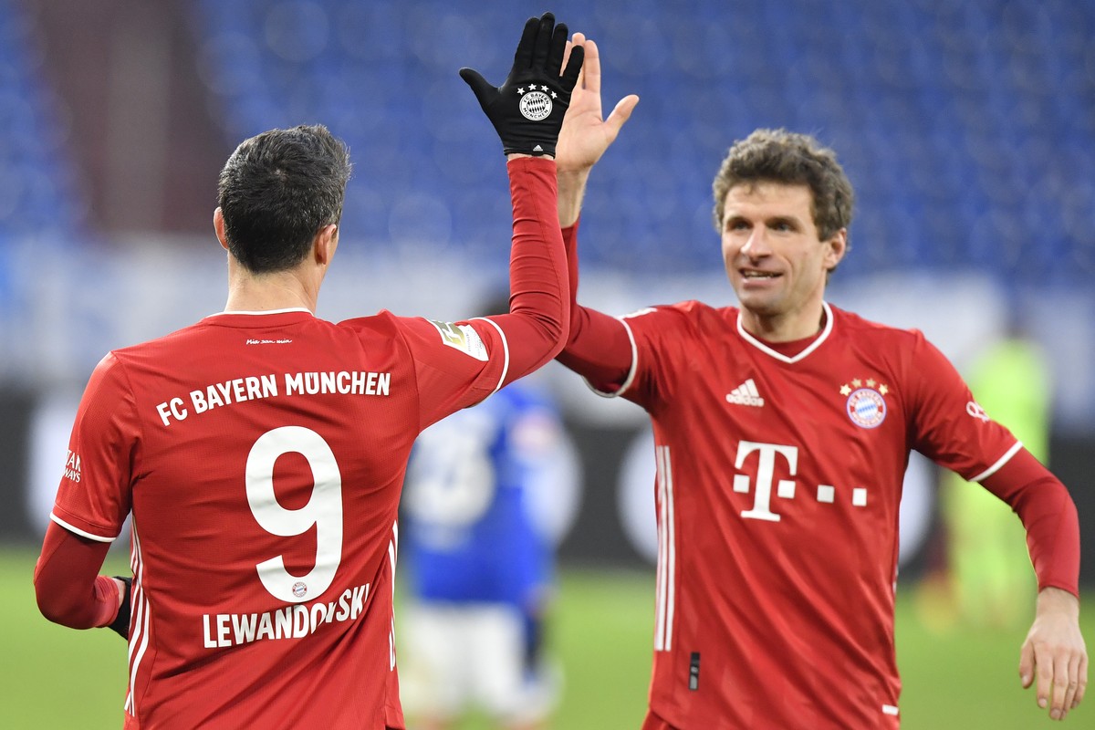 Bayern's Robert Lewandowski, left, celebrates with teammate Bayern's Thomas Mueller after scoring during the German Bundesliga soccer match between FC Schalke 04 and Bayern Munich in Gelsenk ...