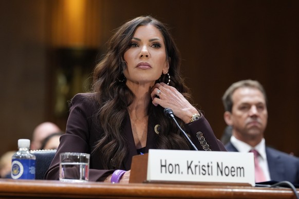 Homeland Security Secretary Kristi Noem, center, with her husband Bryon Noem, right, seated behind her, appears for an oversight hearing before the Senate Judiciary Committee, at the Capitol in Washin ...