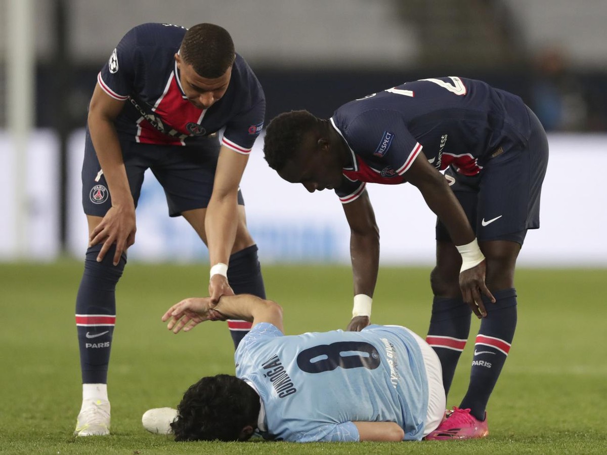 PSG's Kylian Mbappe, left, and PSG's Idrissa Gueye, right, check on Manchester City's Ilkay Gundogan during the Champions League semifinal first leg soccer match between Paris Saint Ger ...