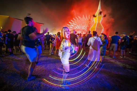 A festival goer spins a light dstrip as she dances to electronic music in front of the Belleville stage during the 45th edition of the Paleo Festival, in Nyon, Switzerland, Sunday, July 24, 2022. The  ...