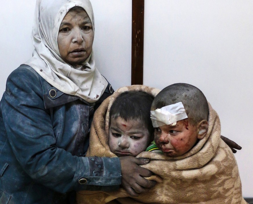 epaselect epa05805233 An injured woman holds injured children at a hospital, after alleged airstrikes by forces loyal to the Syrian government hit areas inhabited by civilians in Barzeh, near Damascus ...