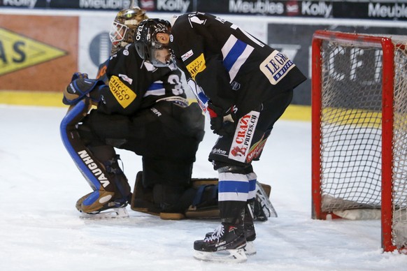 Fribourgs Laurent Meunier und Fribourgs Goalie Barry Brust nach dem Tor zum 1-3 durch Luganos Luca Cunti (nicht im Bild), im vierten Eishockey Playoff-Viertelfinalspiel der National League zwischen de ...