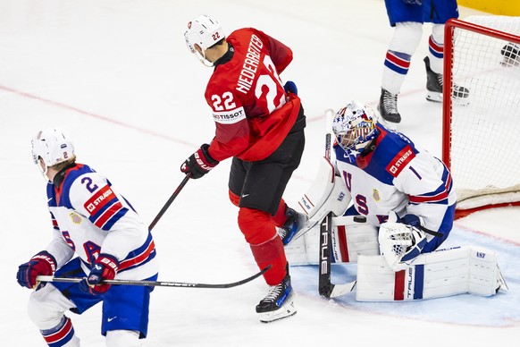 epa12135456 Switzerland&#039;s forward Nino Niederreiter, center, vies for the puck with USA&#039;s goaltender Jeremy Swayman, right, during the IIHF Ice Hockey World Championship final match between  ...