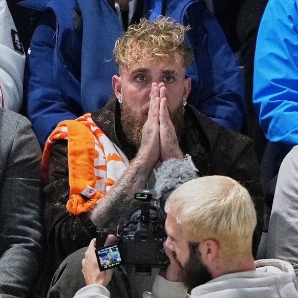 Jake Paul of the U.S., center, watches this fiancé Jutta Leerdam of the Netherlands compete in the women's 1,000 meters speedskating race at the 2026 Winter Olympics, in Milan, Italy, Monday, Feb ...