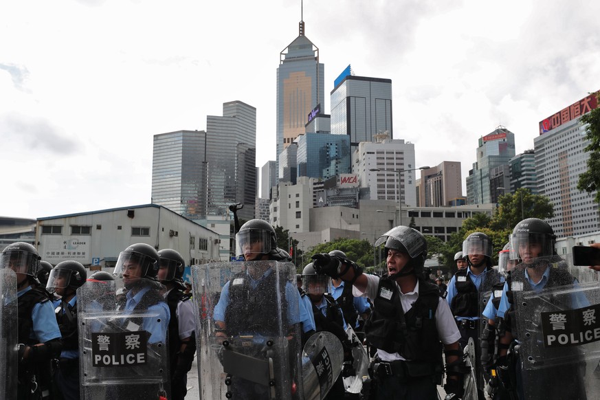 epa07686362 Riot police stand guard as protesters block roads near the Legislative Council in Hong Kong, China, 01 July 2019. Anti-extradition bill protesters vowed to disrupt a flag-raising ceremony  ...