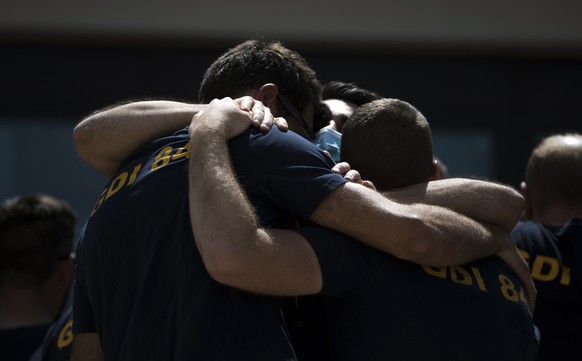 Police officers console each other during a ceremony to commemorate a slain colleague at a police station in Avignon, southern France, Sunday, May 9, 2021. Police officers and civilians gathered to co ...