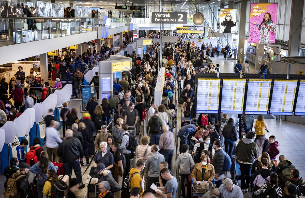 epa09903755 Travelers queue inside the departure hall of the Amsterdam Schiphol Airport, Netherlands, 23 April 2022. KLM personnel responsible for loading and unloading luggage called for a wildcat st ...