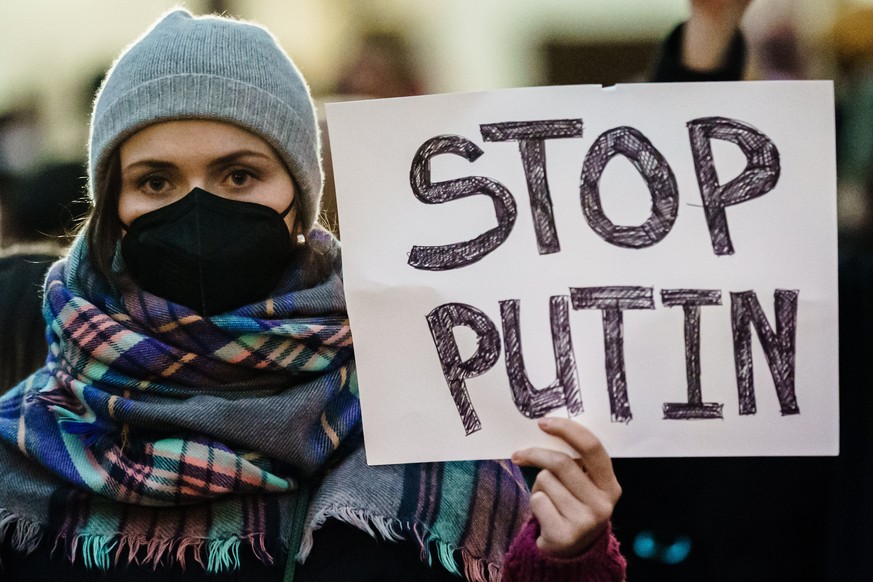 epa09777304 A demonstrator holds a cardboard reading &#039;Stop Putin&#039;, during a rally in front of the Russian embassy in Berlin, Germany, 22 February 2022. Demonstrators gathered in front of the ...