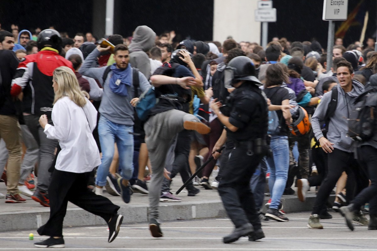 Riot policemen clash with protestors outside El Prat airport in Barcelona, Spain, Monday, Oct. 14, 2019. Riot police have charged at protesters outside Barcelona's airport after the Supreme Court ...