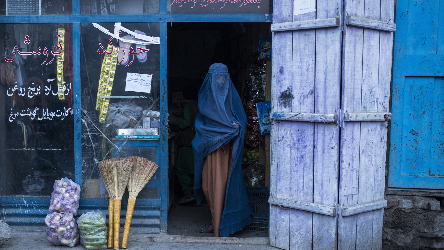 An Afghan woman wearing a burka exits a small shop in Kabul, Afghanistan, Sunday, Dec. 5, 2021. Women&#039;s rights activists in the Afghan capital of Kabul insisted Sunday they would continue fightin ...