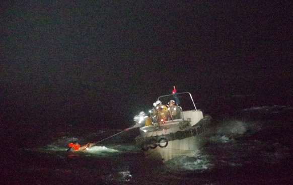 epa08643119 A handout photo made available by the Japan Coast Guard (JCG) 10th Coast Guard Headquarters shows Japan Coast Guard officers rescuing a Filipino crew member of the Gulf Livestock 1 cargo v ...