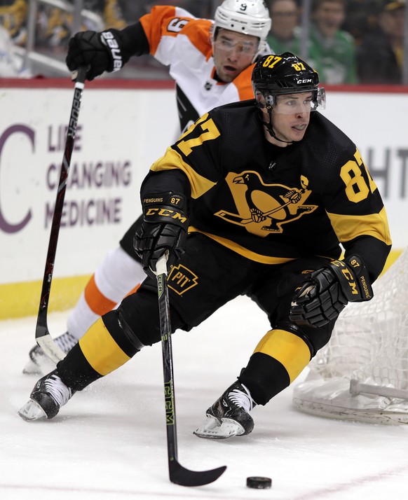 Pittsburgh Penguins&#039; Sidney Crosby (87) wraps around the back of goal with Philadelphia Flyers&#039; Ivan Provorov (9) defending during the second period of an NHL hockey game in Pittsburgh, Sund ...