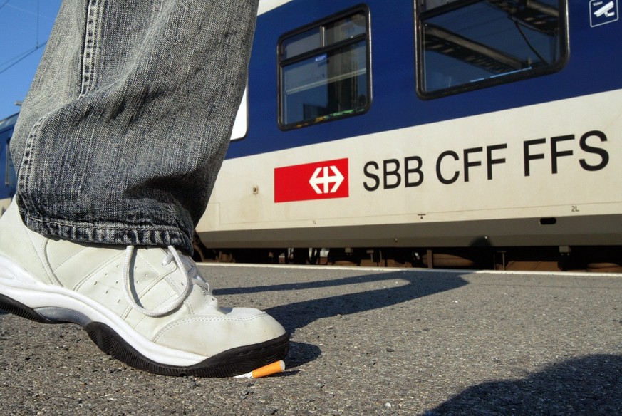 Un homme ecrase sa cigarette avant de monter dans le train ce dimanche 11 decembre 2005 a Yverdon. Aujourd&#039;hui est le premier jour sans cigarettes dans les trains des CFF, SBB, FFS. (KEYSTONE/And ...
