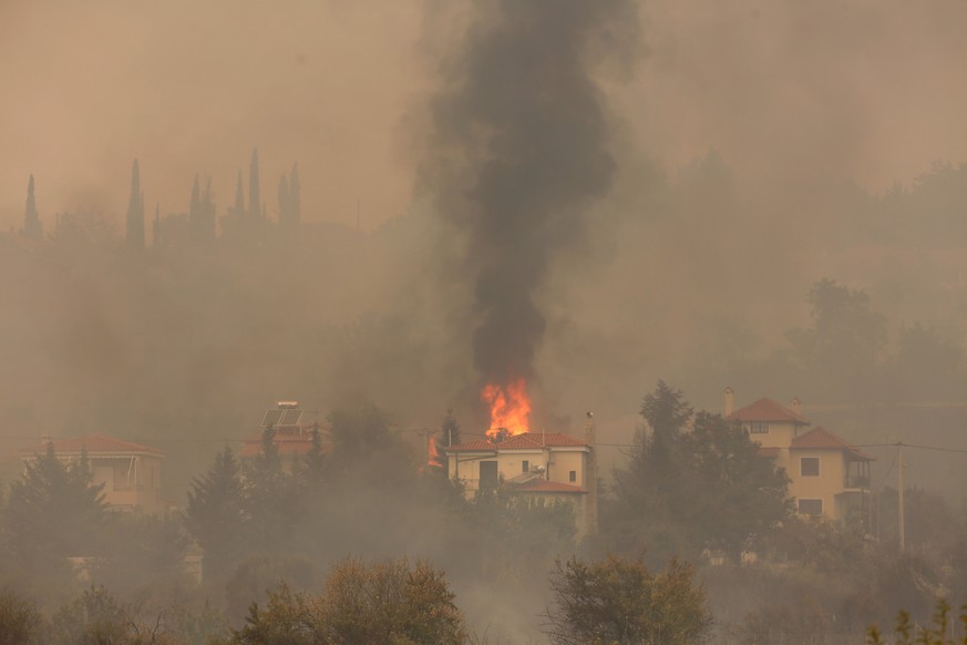 epa09400914 Smoke rises from fires near houses in the Afidnes area, near Athens, Greece, 06 August 2021. The fires in Attica continued to blaze uncontrollably on 06 August, along all three fronts that ...