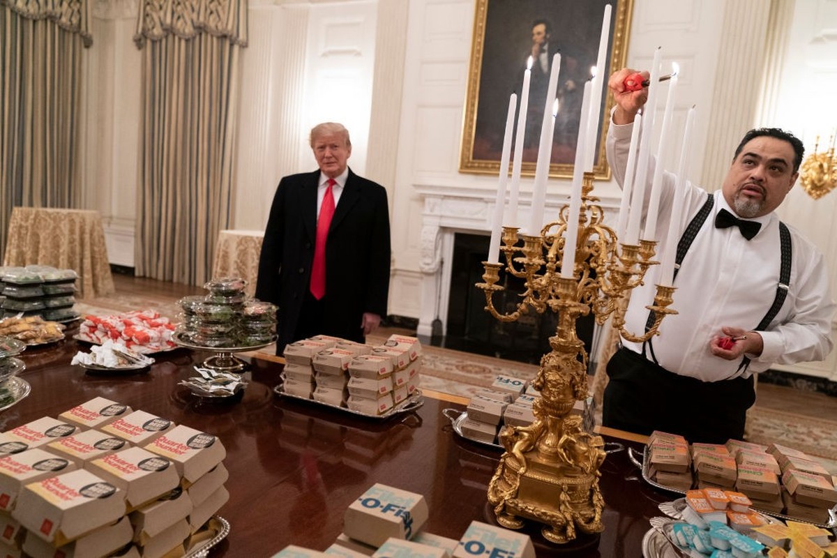 WASHINGTON, DC - JANUARY 14: (AFP OUT) U.S President Donald Trump watches as candles are lit as he presents fast food to be served to the Clemson Tigers football team to celebrate their Championship a ...