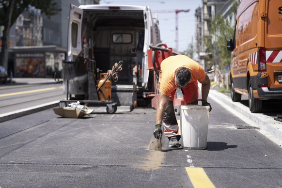 Bauarbeiter arbeiten bei grosser Hitze an der Sonne auf einer Baustelle an der Badenerstrasse, fotografiert am Mittwochnachmittag, 25. Juni 2025 in Zuerich. (KEYSTONE/Gaetan Bally)