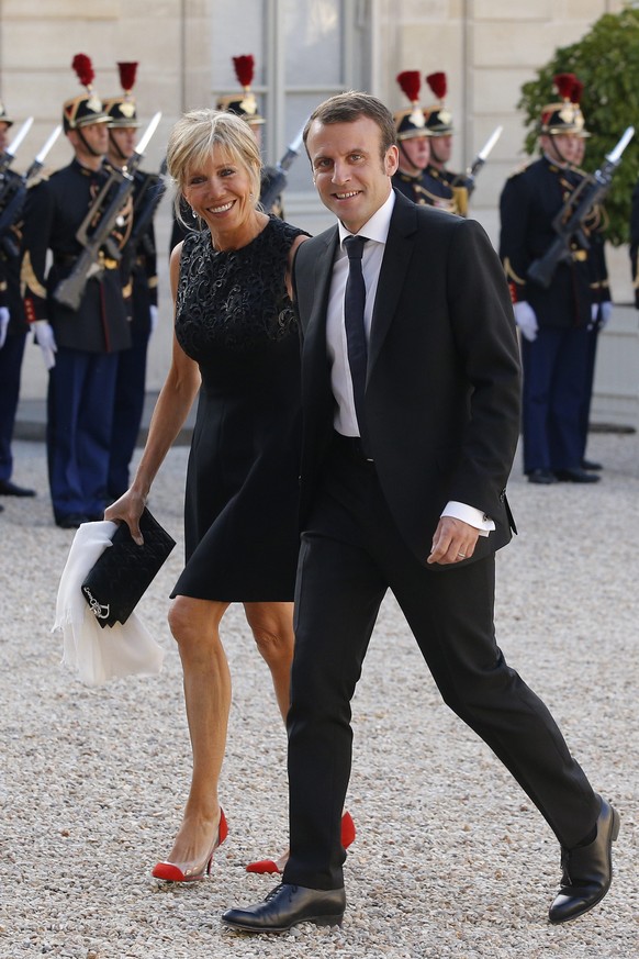 epa04780789 French Economy Minister Emmanuel Macron (R) arrives with his wife Brigitte Trogneux (L) at the Elysee Palace for a state diner in the honor of Spain's King Felipe VI and Queen Letizia, in  ...