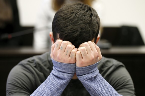 epa07430577 Defendant Ali B., who is accused of murder, covers his face as he arrives for the beginning of his trial at a courtroom of the regional court in Wiesbaden, Germany, 12 March 2019. Ali B. i ...