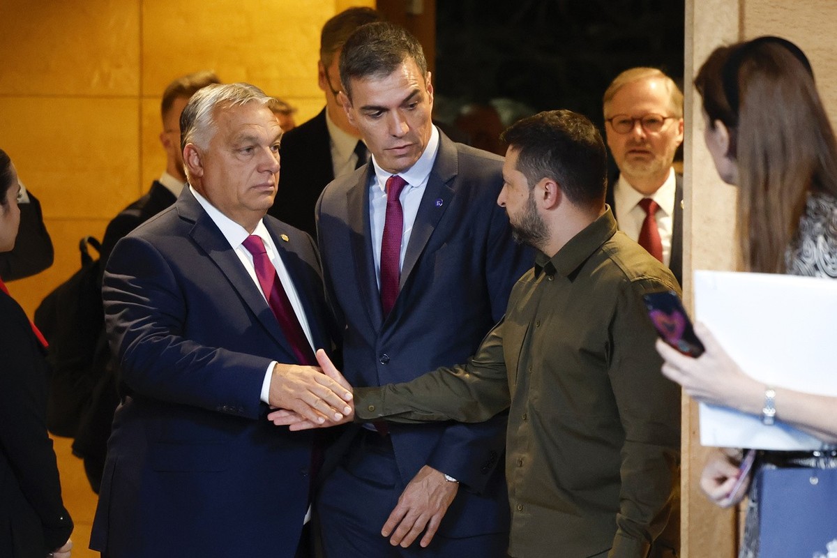 Viktor Orban, Prime Minister of Hungary, left, and Volodymyr Zelensky, President of Ukraine, right, shake hands beside Spain's Prime Minister Pedro Sanchez, center, center, prior to the opening c ...