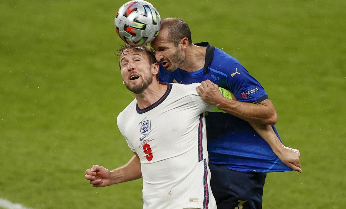 England's Harry Kane, left, and Italy's Giorgio Chiellini compete to head the ball during the Euro 2020 soccer championship final between England and Italy at Wembley stadium in London, Sund ...