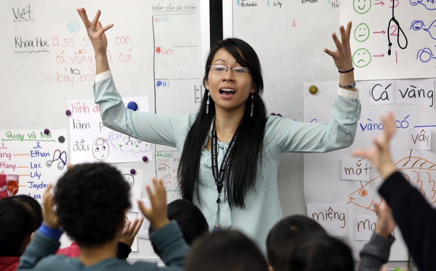 In this photo taken Friday, Feb. 14, 2014, kindergarten teacher Thao Tran teachers kindergartners in a dual immersion language class at White Center Heights Elementary School in Seattle. In a handful  ...
