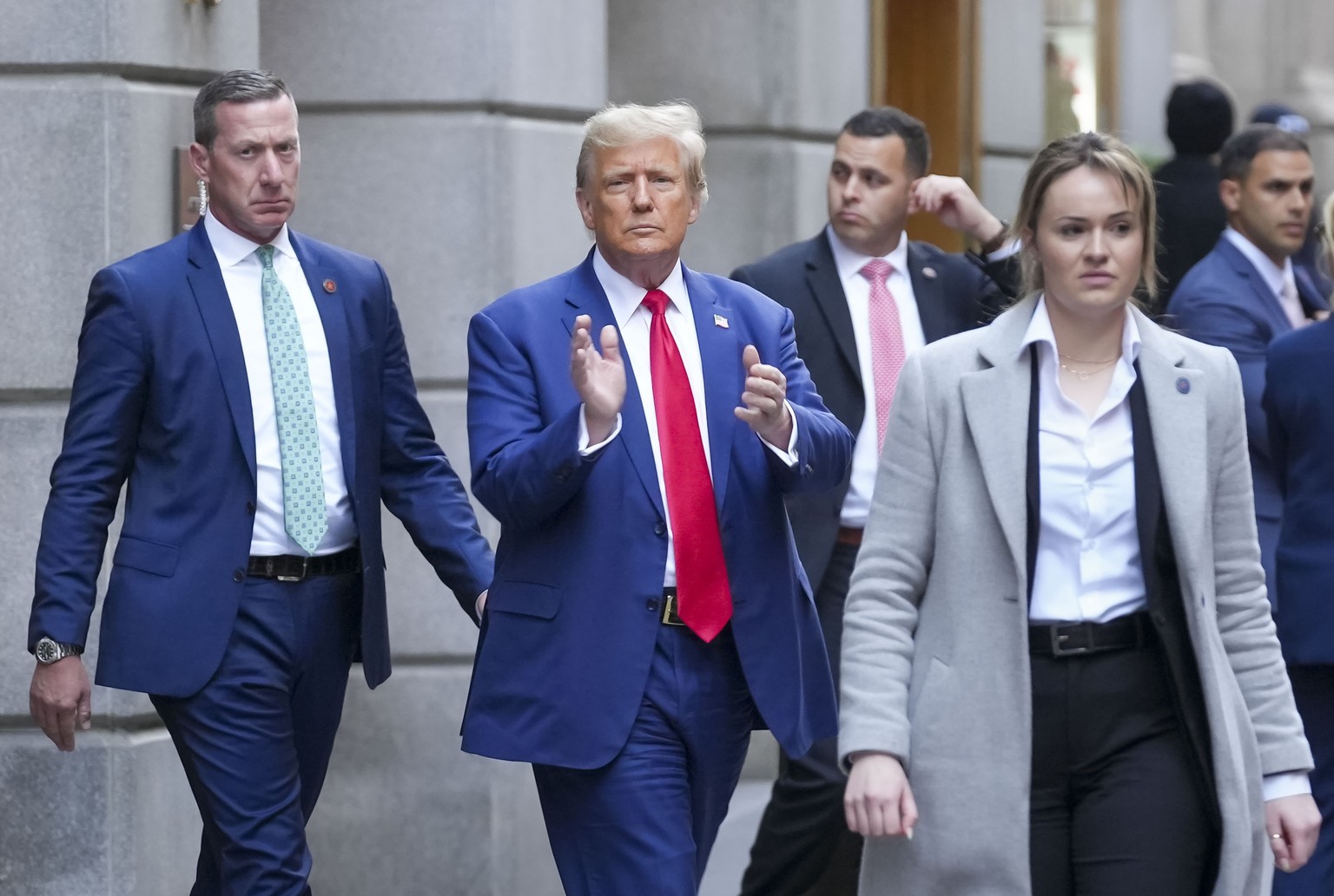 epa11070335 Former US President Donald J. Trump (C) acknowledges a crowd as he exits a building in Lower Manhattan after attending the civil fraud trial being litigated against the Trump Organization  ...
