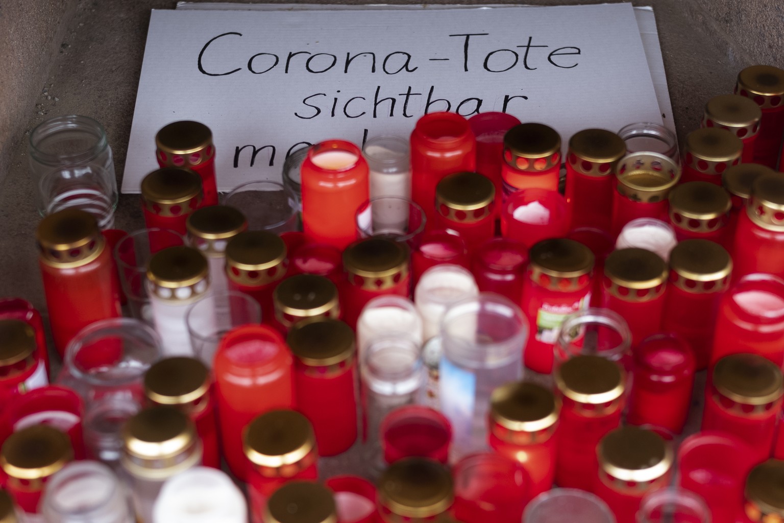 Candles placed for a paper reading &#039; Make the Corona Death visible&#039;, at a makeshift memorial side at the Arnsfelder Platz square in Berlin, Germany, Thursday, Jan. 7, 2021. Germany recorded  ...