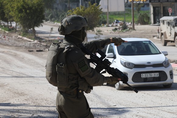 epa11924264 An armed Israeli soldier gestures as they take position in the West Bank city of Jenin, 25 February 2025. The Israeli military launched a military operation in Jenin and its camp on 21 Jan ...