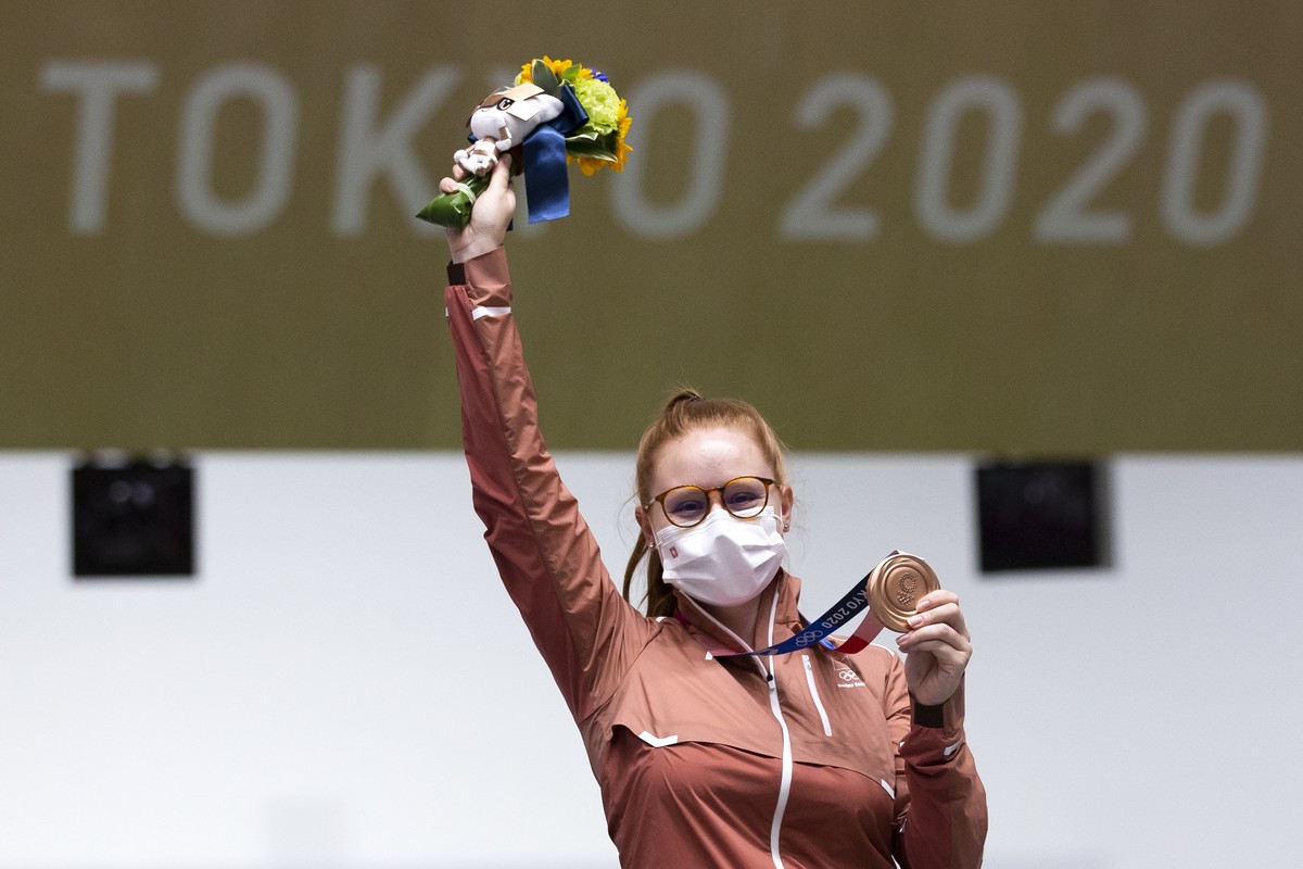 Nina Christen of Switzerland celebrates on the podium after winning the bronze medal in the women's shooting 10m air rifle final at the 2020 Tokyo Summer Olympics in Tokyo, Japan, on Saturday, Ju ...